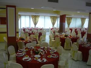 a banquet hall with red and white tables and chairs at Hotel Val Di Sangro in Perano