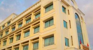 a yellow building with windows on the side of it at Seng Aroun Hotel in Pakse