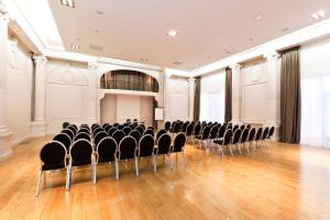 una habitación vacía con sillas y un escenario. en Mercure Lille Roubaix Grand Hôtel en Roubaix