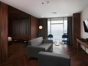 a living room with a couch and a chair at The Bono Hotel Pekanbaru in Pekanbaru