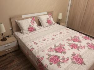 a bedroom with a bed with pink flowers on it at Sunshine Apartment in Pomorie
