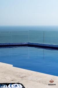 a swimming pool with the ocean in the background at ame&buho in Acapulco