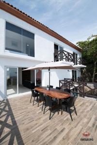 a wooden table with chairs and an umbrella on a patio at ame&buho in Acapulco