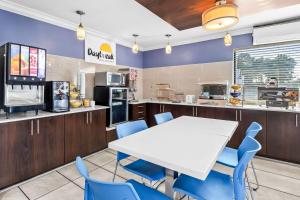 a dining room with a white table and blue chairs at Days Inn by Wyndham Goose Creek in Charleston