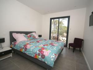 a bedroom with a bed and a window and a chair at Modish Villa in Vidauban France With Swimming Pool in Vidauban
