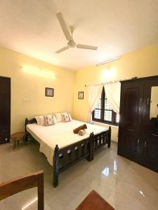 a bedroom with a bed with a ceiling fan at Tattwamasi Annex with Breakfast and Yoga in Varkala