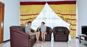 a man and a woman sitting on a couch at Hotel Glee in Trincomalee