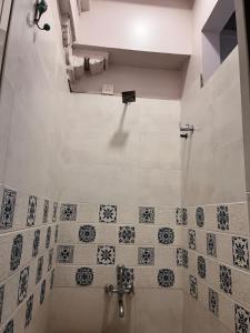 ein Bad mit Dusche und Wandfliesen in der Unterkunft Savita Ba Ni Haveli A Heritage House in Ahmedabad