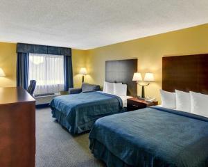 a hotel room with two beds and a desk at Quality Inn & Suites Grand Prairie South in Florence Hill +50 photos