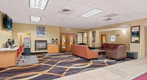 a lobby with couches and a couch and a fireplace at AmericInn by Wyndham Denver Airport in Denver