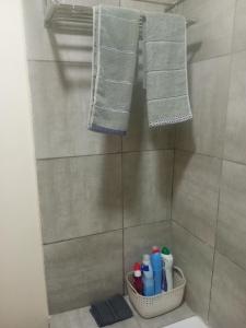 a bathroom with a shower with towels and toothbrushes at Skimbo's Apartment in Lusaka +12 photos