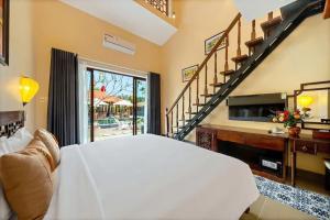 a bedroom with a large white bed and a staircase at Zen B Hoian Villa in Cam Thanh