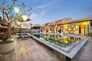 a hotel with a pool in front of a building at Zen B Hoian Villa in Cam Thanh