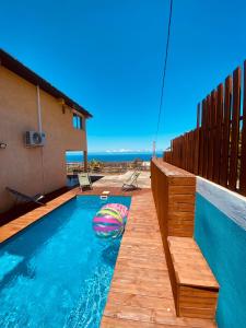 a swimming pool with a beach ball in the water at La Caza Léo - 120m² - Piscine vue sur mer in Étang-Salé