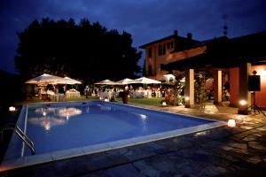 a large swimming pool in a yard with a restaurant at Torre dei Frati Bed & Breakfast in Fossano