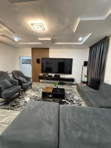 un salon avec des canapés et une télévision à écran plat dans l'établissement H Residence, à Wupa 16 autres photos