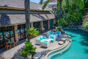 塞米亚克Maca Villas & Spa Bali的一个带椅子的户外甲板和游泳池