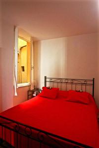 a red bed with red pillows in a bedroom at Vernazza Vacation 2 in Vernazza