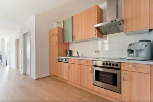 kuchnia z drewnianymi szafkami i piekarnikiem w obiekcie cosy apartment in perfect location w Wiedniu +15 zdjęć