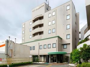 a tall white building with a parking lot at New Biwako Hotel in Otsu