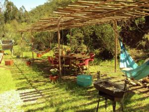 une pergola en bois avec une table et des chaises sous celle-ci dans l'établissement Quiet and cottage in the estate Casas da Cerca near Troviscais, à Troviscais