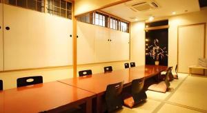a conference room with a long wooden table and chairs at Chino Station Hotel in Chino