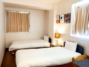 那覇市にあるHotel-澄Sumiのベッドが2つと窓があるホテルの部屋 +4枚の写真