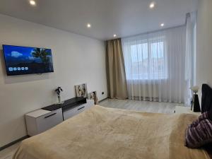 a bedroom with a bed and a tv on the wall at Новинка ЖК Тріумф поряд вокзалу in Luts'k