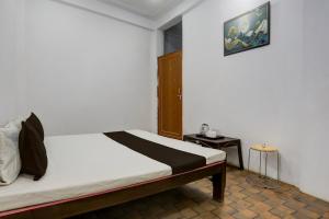 Un dormitorio con una cama y un cuadro en la pared. en SPOT ON S.M. HOTEL, en Ghoghāpur
