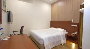 a bedroom with a bed and a table and a desk at Elegant Hotel in Batu Pahat +44 photos