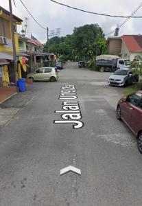 a street with cars parked on the road at Asyun Homestay 1 in Sungai Buluh