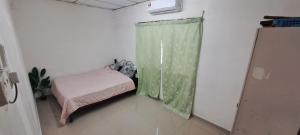 a small room with a bed and a window at Asyun Homestay 1 in Sungai Buluh