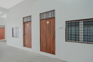two wooden doors in a room with two windows at SPOT ON Hotel Veer Galaxy in Ghātampur