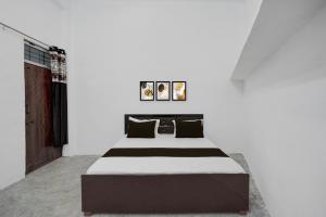 a bed in a room with a white wall at SPOT ON Hotel Veer Galaxy in Ghātampur