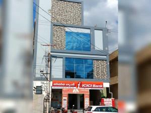 a building with a car parked in front of it at Hotel O Shrihaan Residency in Rāmachandrapuram