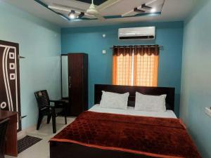 a bedroom with a bed and a chair and a window at Hotel O Shrihaan Residency in Rāmachandrapuram