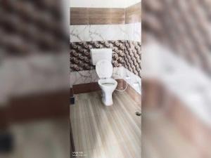 a bathroom with a white toilet in a room at SPOT ON New Phulpur Restaurant And Hotel in Phūlpur