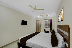 a bedroom with a bed and a ceiling fan at Hotel O Golden Paradise in Haidar Sāhibgūda