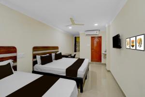 Haidar SāhibgūdaにあるHotel O Golden Paradiseのベッド2台とテレビがあるホテルの部屋