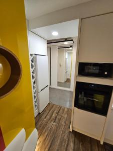 una cocina con nevera y microondas en Apartman ALEK Stupine ,Tuzla, en Tuzla