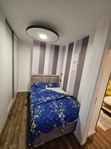 Un dormitorio con una cama y una pared rayada. en Apartman ALEK Stupine ,Tuzla, en Tuzla