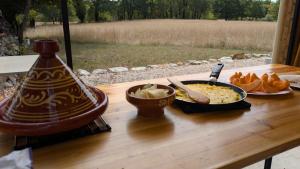 a table with a bowl of food and a plate of food at Le chalet du bien-être in Vailhourles