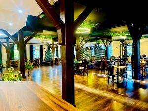 a restaurant with wooden floors and tables and chairs at Zajazd Piękna Góra in Gołdap