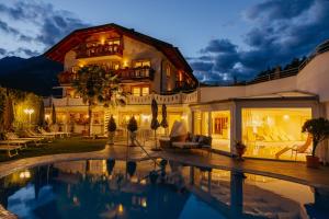 a house with a swimming pool in front of it at Adults only Hotel Grafenstein in Schenna
