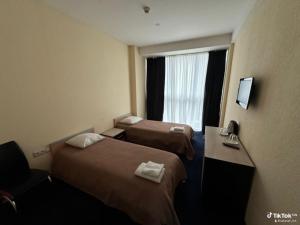 a hotel room with two beds and a window at Rustaveli Inn რუსთაველი ინნ in Rustavi