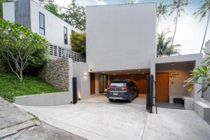 a car parked in the driveway of a house at Sparrow Villa - Kamala Beach in Kamala Beach