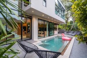 a swimming pool in a house with a pink swan in the water at Sparrow Villa - Kamala Beach in Kamala Beach