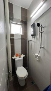a small bathroom with a toilet and a window at Singah in Bukit Mertajam +3 photos