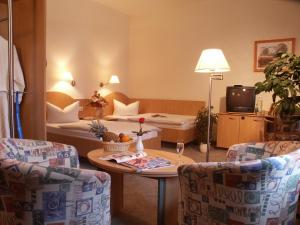 バート・シュレーマにあるKurhotel Bad Schlemaのベッド、テーブル、椅子が備わるホテルルームです。
