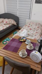 a table with cups and saucers on top of a bed at München Haus-Centrum-Messe-Oktoberfest -7-24 CHECKIN in Munich